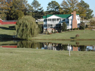 House and willow tree reflected in pond